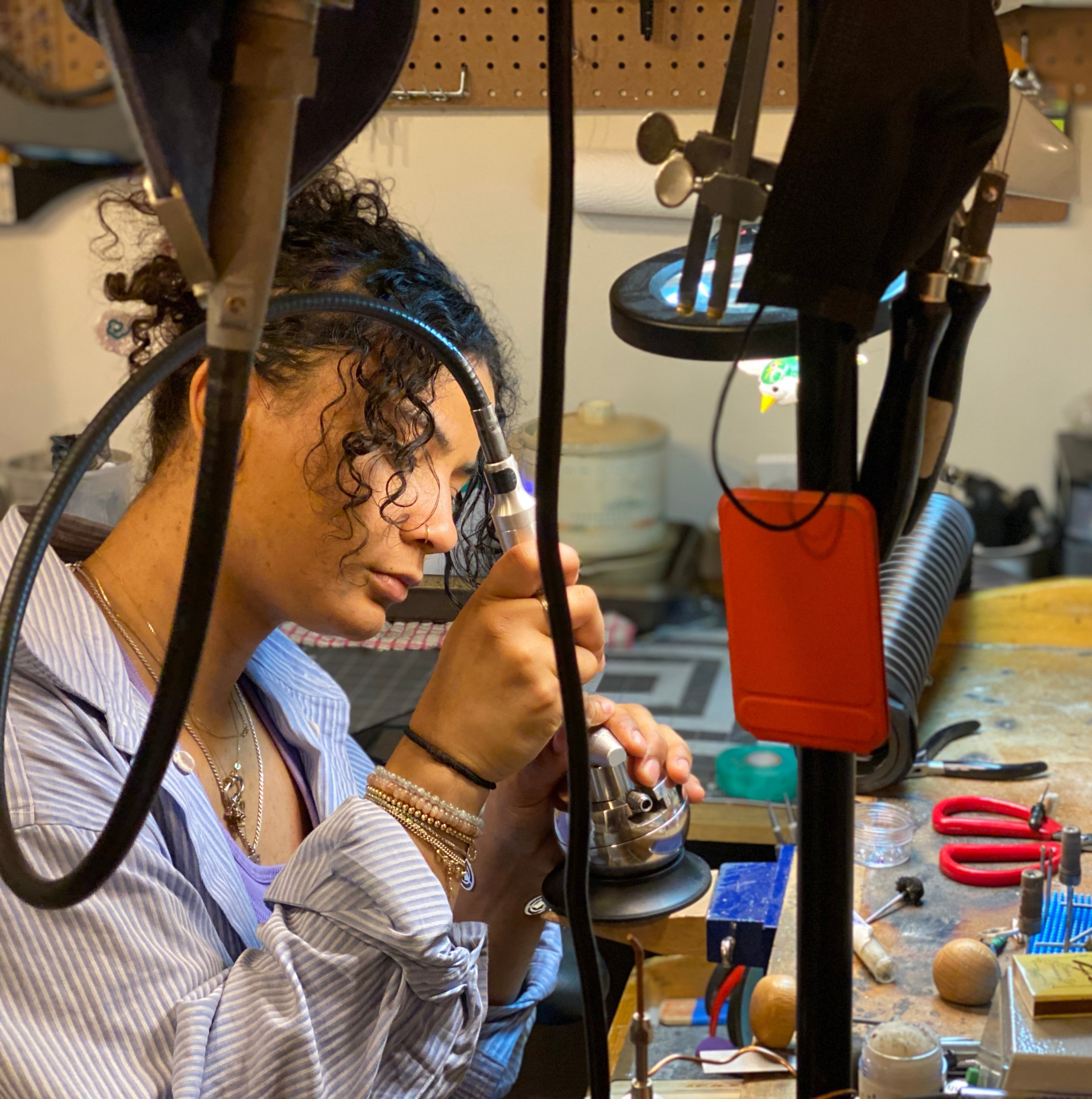 Person working on a project in a workshop with tools and equipment around